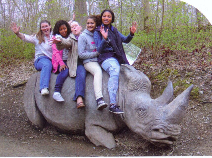 Girls on a stone white rhinoceros