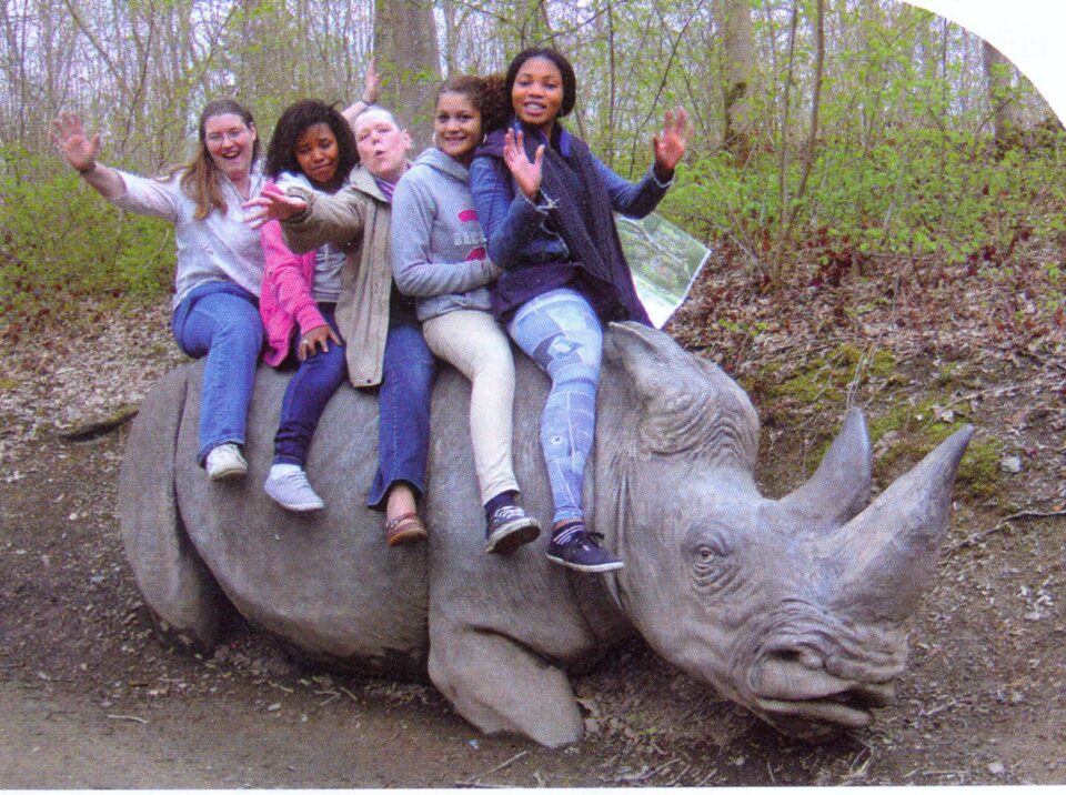 Girls on a stone white rhinoceros